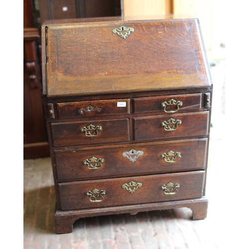 1910 - George III oak bureau, the fall front above an unusual arrangement of short and long drawers on brac... 