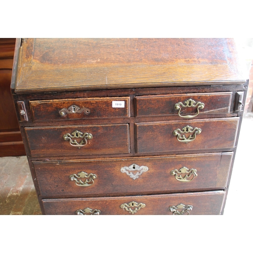 1910 - George III oak bureau, the fall front above an unusual arrangement of short and long drawers on brac... 