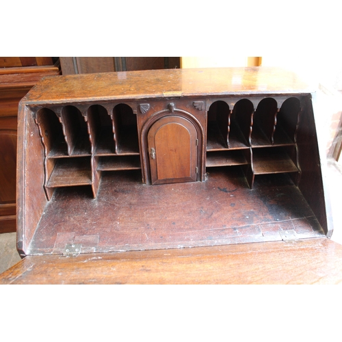 1910 - George III oak bureau, the fall front above an unusual arrangement of short and long drawers on brac... 