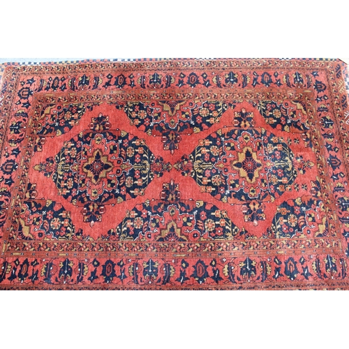 23 - Afghan rug with a twin medallion design on a brick red ground with borders, 190 x 130cm