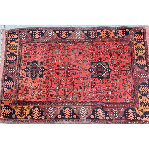 25 - Small Belouch rug with a twin medallion and all-over stylised floral design on a red ground with bor... 