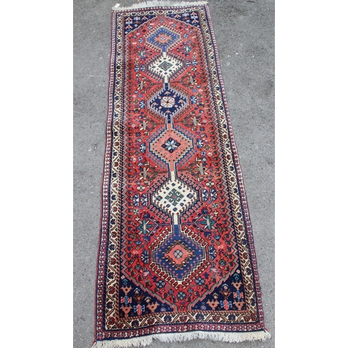 27 - Small Kurdish runner with a linked hooked medallion design on a rose ground with borders, 192 x 65cm