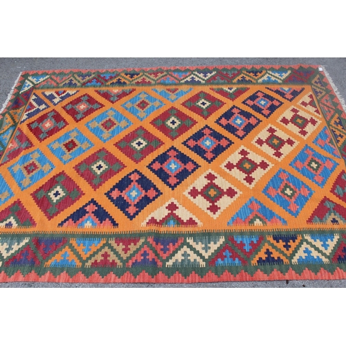 31 - Modern Kelim rug with a polychrome stylised design on a terracotta ground with borders, 237 x 170cm