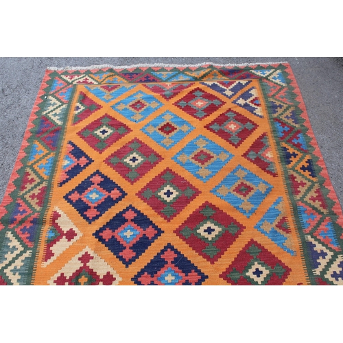 31 - Modern Kelim rug with a polychrome stylised design on a terracotta ground with borders, 237 x 170cm