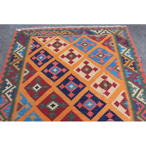 31 - Modern Kelim rug with a polychrome stylised design on a terracotta ground with borders, 237 x 170cm