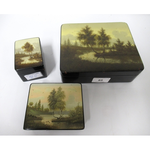 85 - Group of three various Russian lacquered boxes, the lids painted with river landscapes