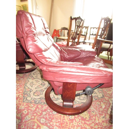 1855 - Stressless pair of burgundy leather upholstered tub chairs with foot stools