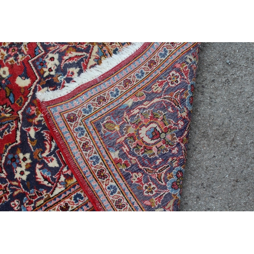 1 - Modern Kashan carpet with all-over floral decoration on a red ground with multiple borders, 300 x 20... 