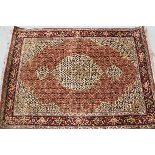 10 - Good quality Indo Persian rug with a lobed medallion and all-over Herati design on a brick red and b... 