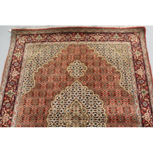 10 - Good quality Indo Persian rug with a lobed medallion and all-over Herati design on a brick red and b... 