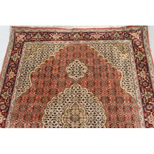 10 - Good quality Indo Persian rug with a lobed medallion and all-over Herati design on a brick red and b... 