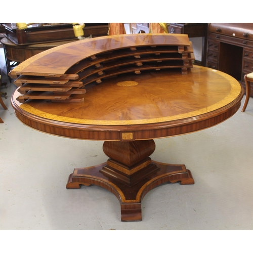 1676 - Jupe type mahogany and ash banded dining table, the quarter veneered circular top with four outer le... 