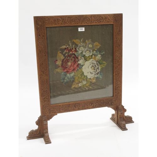 1682 - Early 20th Century carved oak firescreen inset with a needlepoint floral panel, 73cm wide