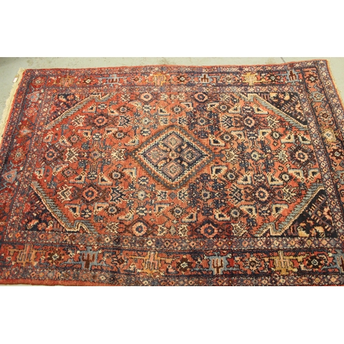 7 - Hamadan rug of medallion and all-over floral design with multiple borders on a red ground, 208 x 104... 