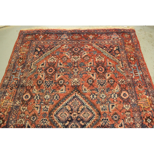 7 - Hamadan rug of medallion and all-over floral design with multiple borders on a red ground, 208 x 104... 