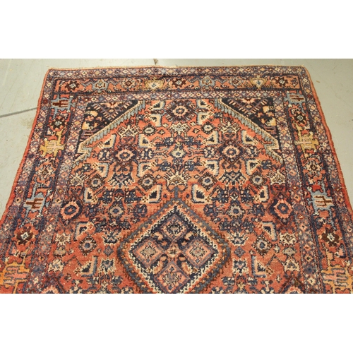 7 - Hamadan rug of medallion and all-over floral design with multiple borders on a red ground, 208 x 104... 