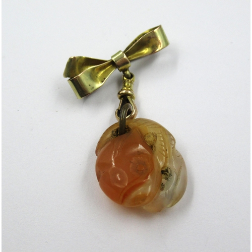 717 - Small carved jade pendant on a 9ct gold bow and clip