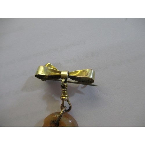 717 - Small carved jade pendant on a 9ct gold bow and clip