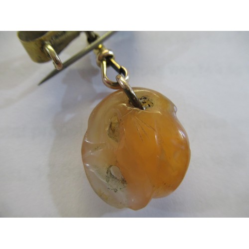 717 - Small carved jade pendant on a 9ct gold bow and clip