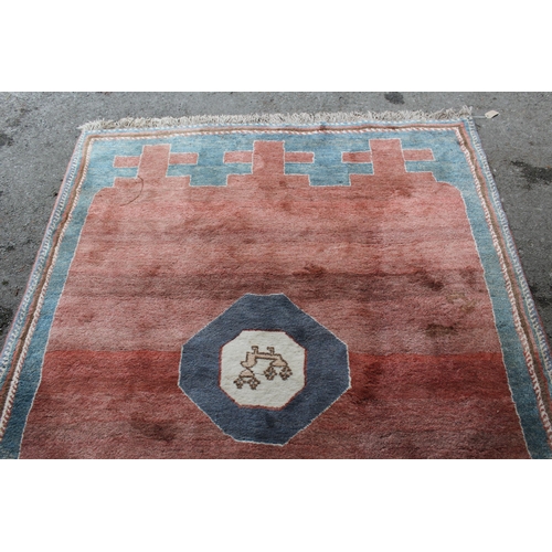 13 - Gabbeh style rug with a centre medallion and plain rust ground with borders, 229 x 168cm