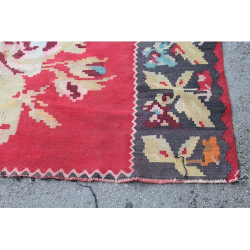 18 - Kelim carpet with stylised floral design on a red ground with border (cuts to both ends), 272 x 278c... 