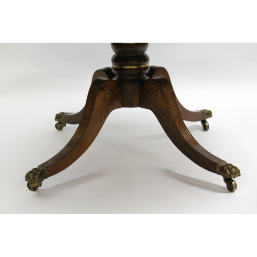 1856 - Regency circular rosewood and brass inlaid tilt top centre table, on turned column and four scroll s... 