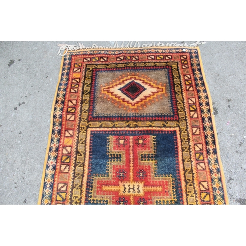 19 - Polychrome tribal rug, possibly Berber, with a triple medallion design and borders, 215 x 113cm