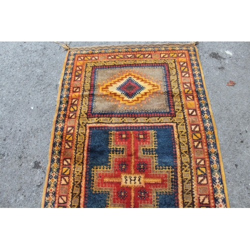 19 - Polychrome tribal rug, possibly Berber, with a triple medallion design and borders, 215 x 113cm