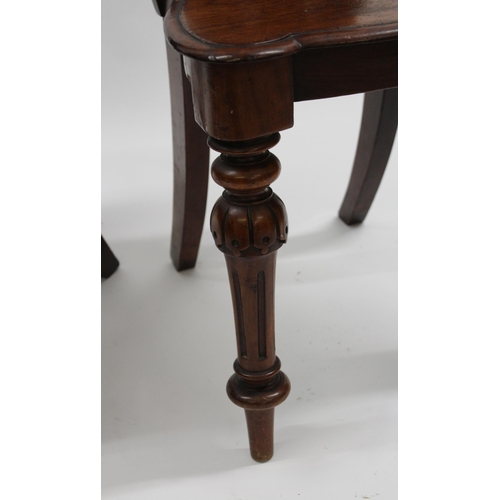 1990 - Pair of Victorian mahogany hall chairs, the shaped carved backs above panel seats and turned fluted ... 