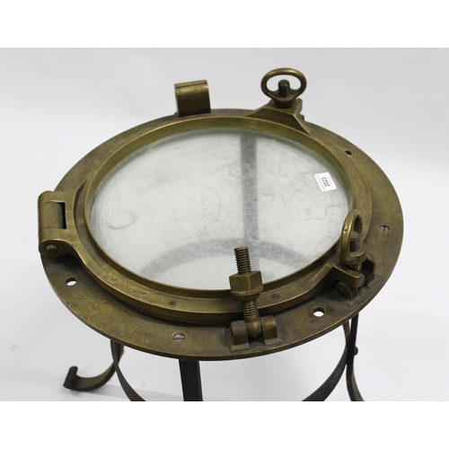 2023 - Large brass porthole cover adapted for use as an occasional table on a wrought iron stand, 50 x 60cm... 