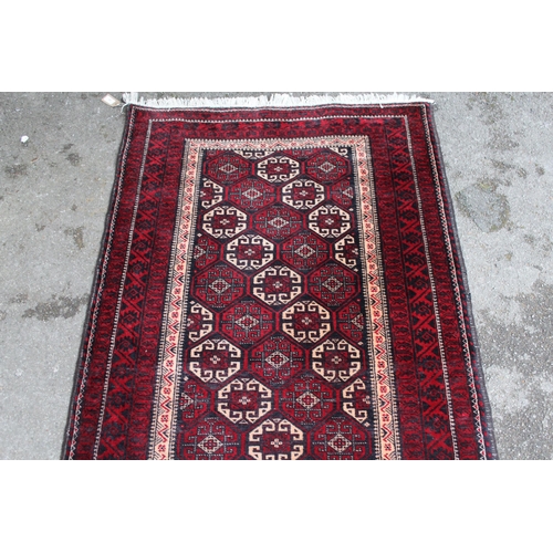 24 - Modern Belouch rug with an all-over hooked medallion design, in shades of ivory, red and dark blue, ... 