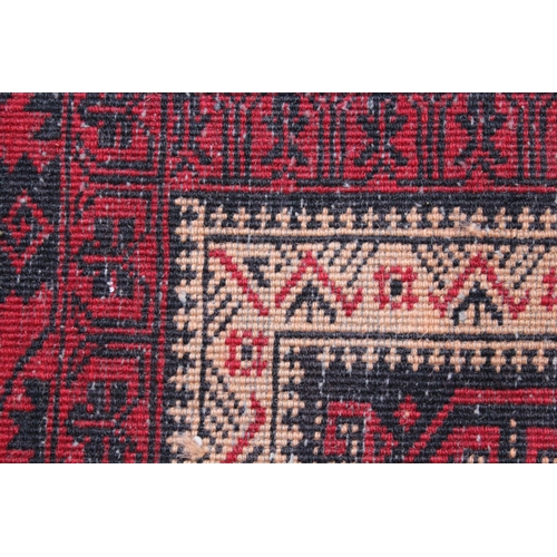 24 - Modern Belouch rug with an all-over hooked medallion design, in shades of ivory, red and dark blue, ... 