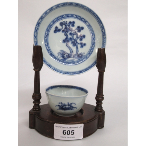 605 - Nanking Cargo blue and white tea bowl and saucer, the saucer 10cm diameter on a hardwood stand