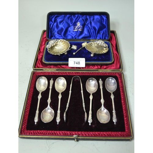 748 - Cased pair of silver shell form salts with spoons, together with a cased set of silver plated apostl... 