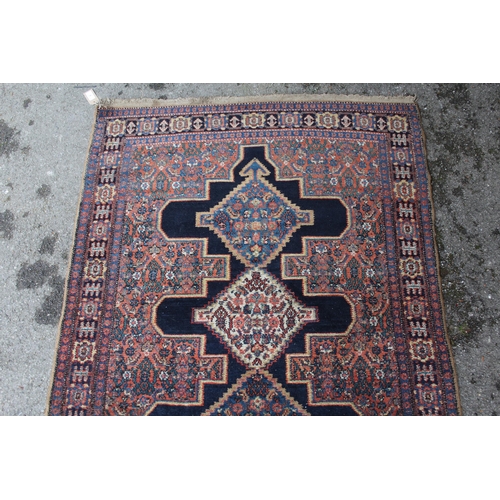 9 - Small Senneh rug with a triple medallion on a midnight blue ground with subsidiary Herati design and... 