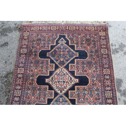 9 - Small Senneh rug with a triple medallion on a midnight blue ground with subsidiary Herati design and... 