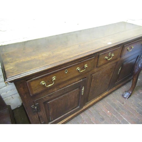 2012B - George III oak dresser base, the moulded top above three drawers and two doors flanking fixed centre... 