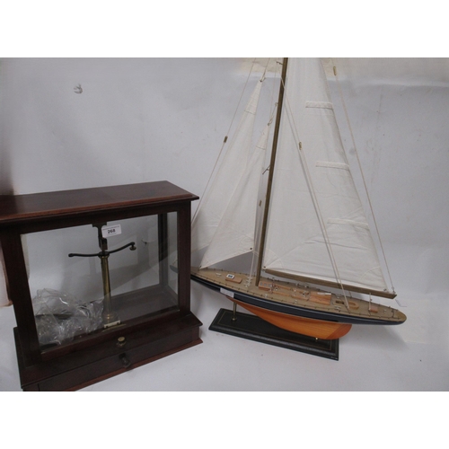 268 - Mahogany cased set of balance scales, together with a wooden model pond yacht