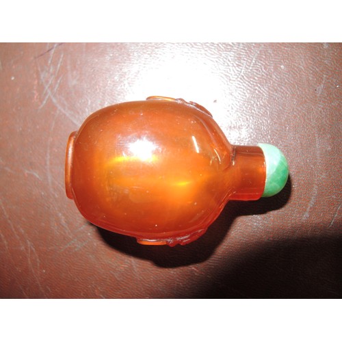 464 - Chinese amber snuff bottle, with lion mask handles and a jade stopper, 53mm high including stopper