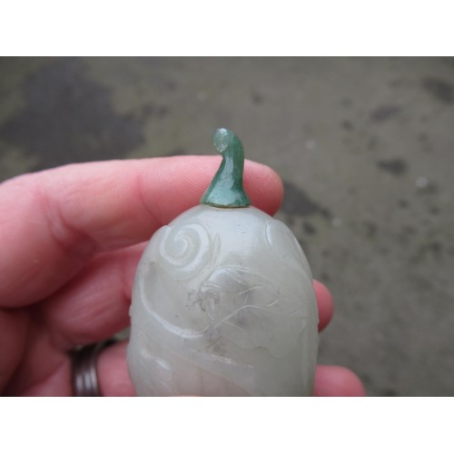 460 - Chinese pale green jade snuff bottle, with floral relief carved decoration and a dark green jade sto... 