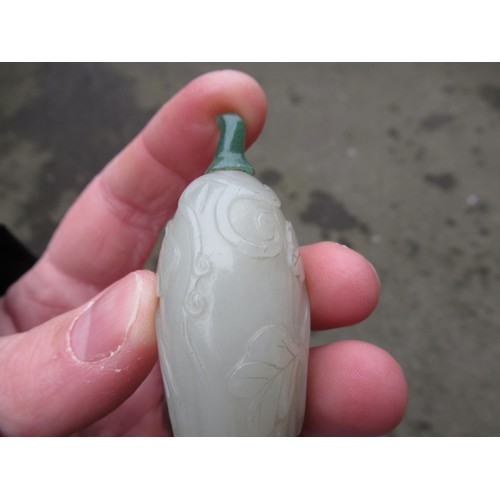 460 - Chinese pale green jade snuff bottle, with floral relief carved decoration and a dark green jade sto... 