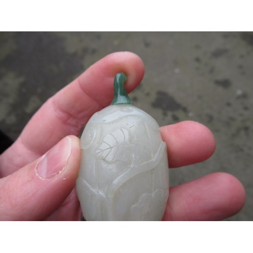 460 - Chinese pale green jade snuff bottle, with floral relief carved decoration and a dark green jade sto... 