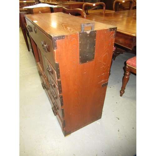 1962 - Japanese elm side cabinet, having iron mounts and handles, with arrangement of various drawers and s... 