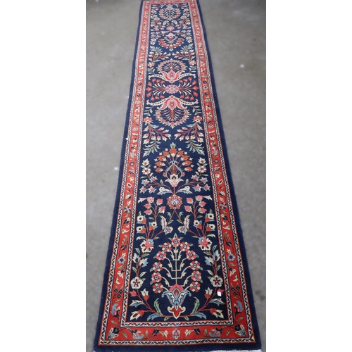 13 - Indo-Persian runner with stylised floral design on a midnight blue ground with borders, 360 x 73cm