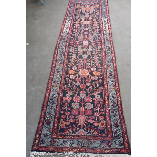 19 - Hamadan runner with an all-over stylised floral design on a dark ground with borders, some wear, 290... 