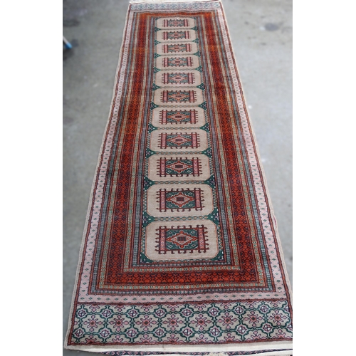 20C - Pakistan runner of Turkoman design with a single row of eleven gols on a beige ground with borders, ... 