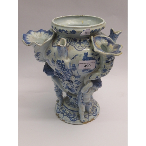 499 - Antique Delft pottery tulip vase on three cherub supports, 27cm high (with damages)