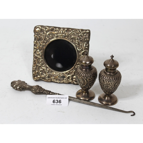 636 - Small silver photograph frame, silver button hook, and two small silver peppers