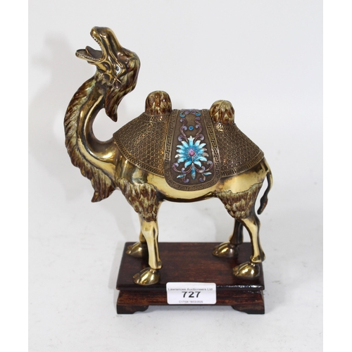 727 - Middle Eastern gilded white metal and enamel decorated figure of a camel, on an integral wooden plin... 