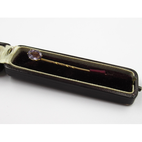 734 - 19th Century gold stick pin, mounted with an oval mauve sapphire